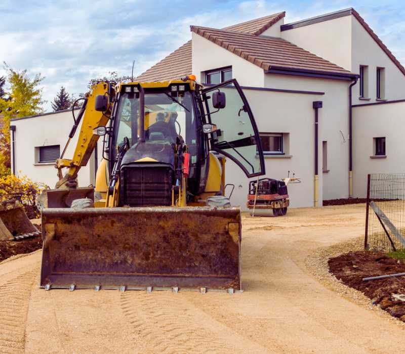 Terrassement de maison individuelle avec engin de chantier sur terrain préparé